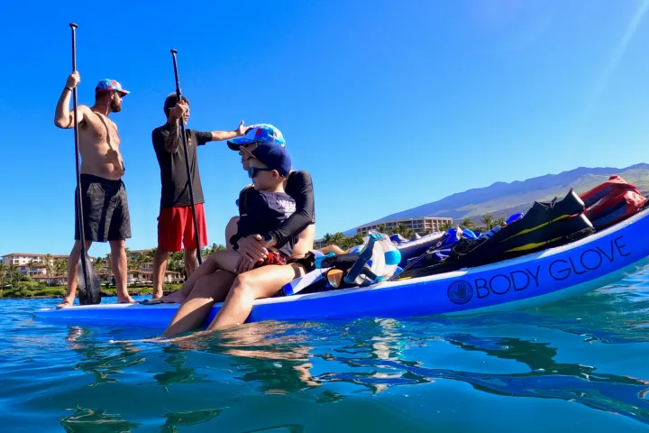 a group of people riding on the back of a boat in the water